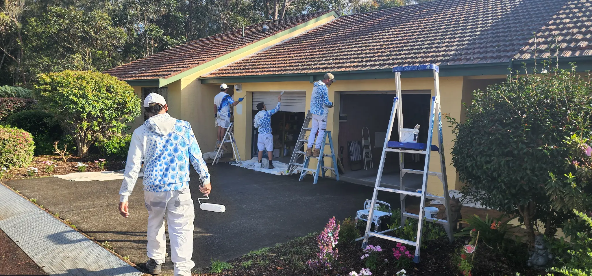 Our painters working on a yellow house